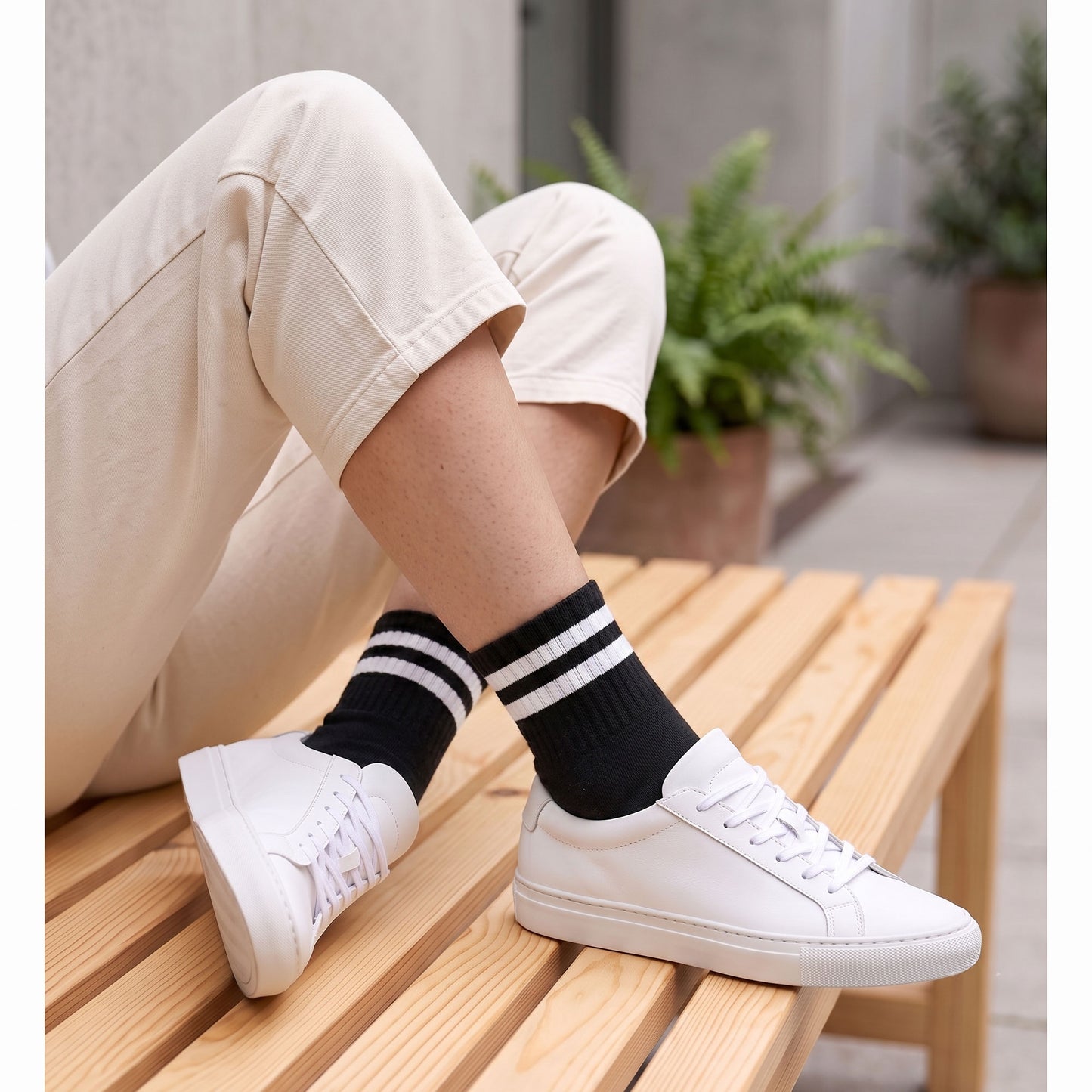 Black half-crew socks with white stripes worn with white trainers