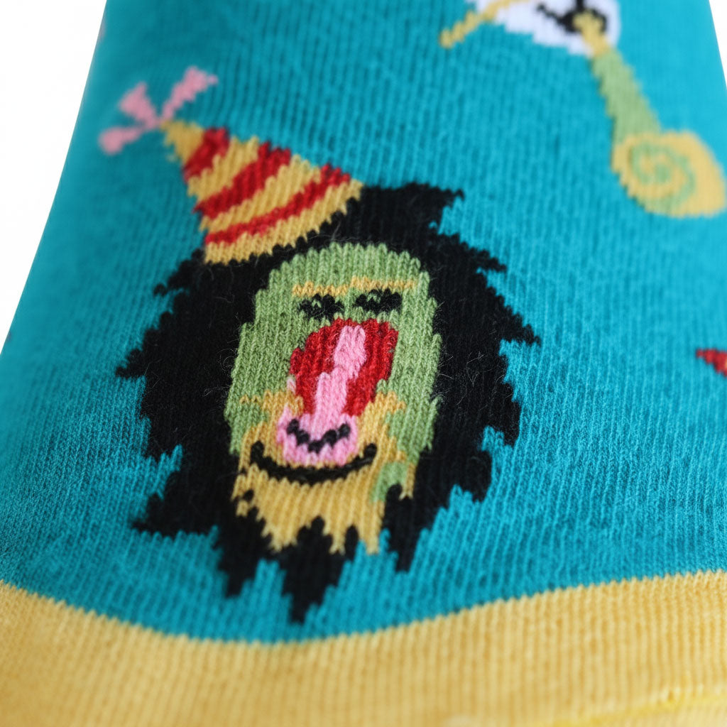Sock with a colorful design of a face wearing a party hat on a blue and yellow background