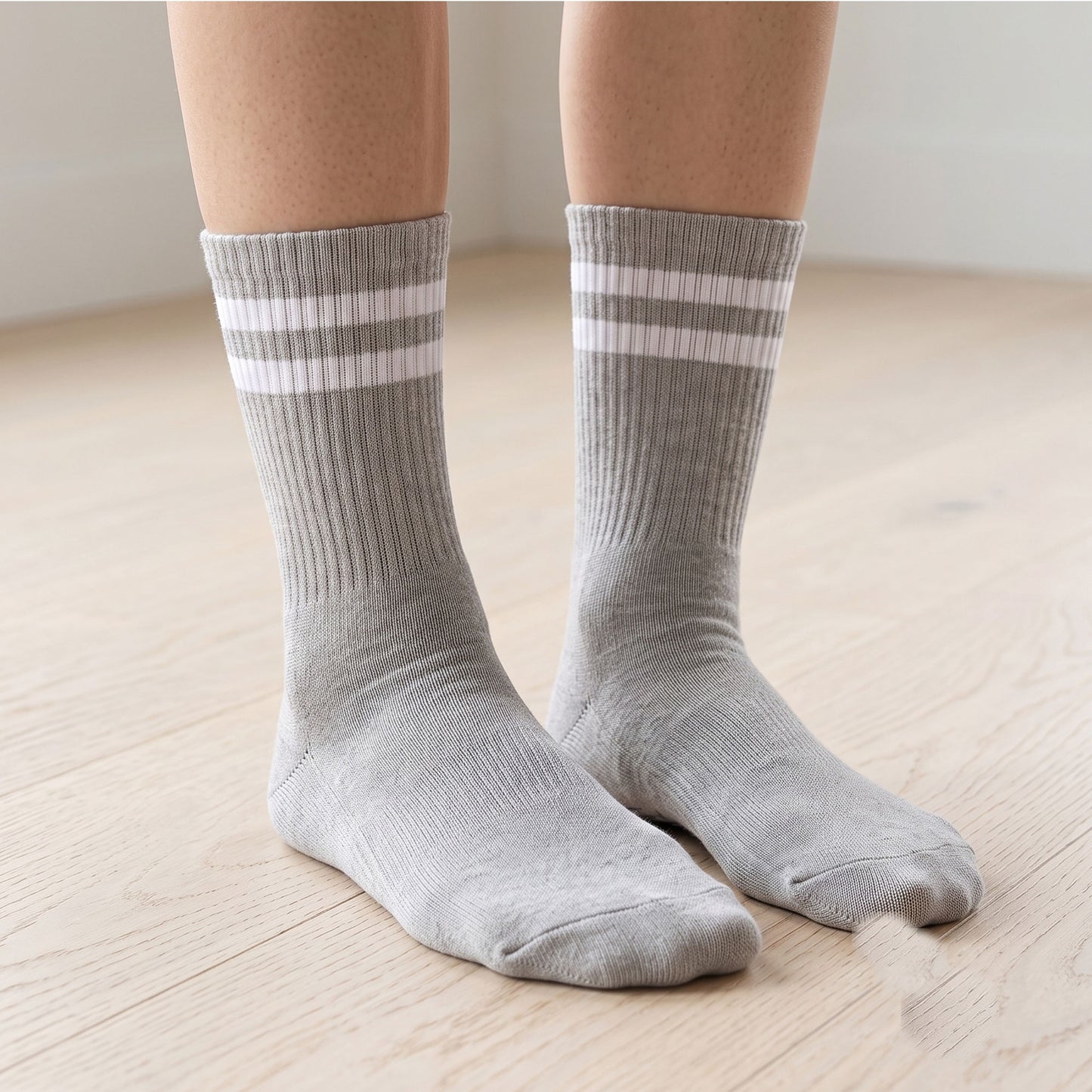 Model wearing grey ribbed crew grip socks with double stripe on a wood floor