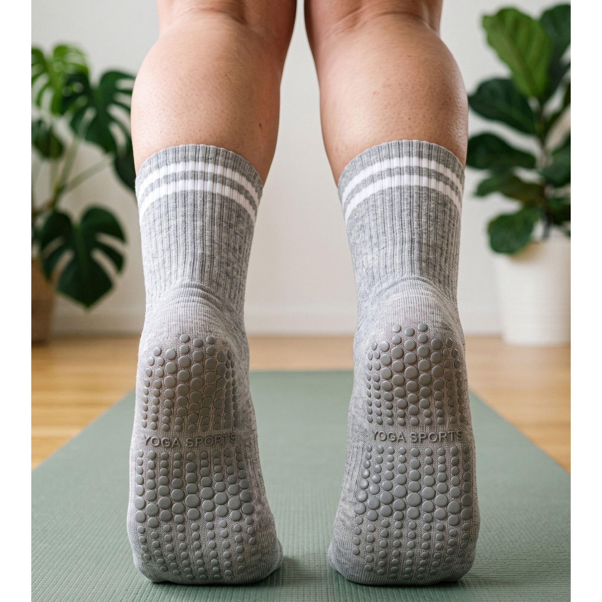 Back view of grey crew grip socks with grip soles on a yoga mat
