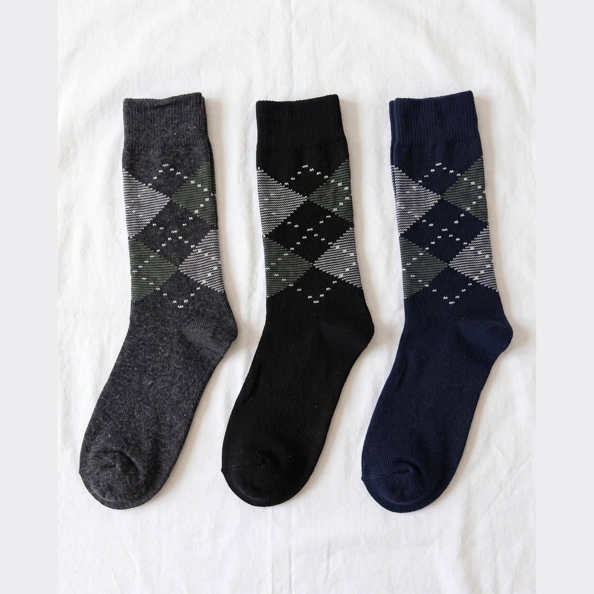 Louluu Argyle lambswool crew socks in charcoal, black and navy with grey and green diamonds — flat lay