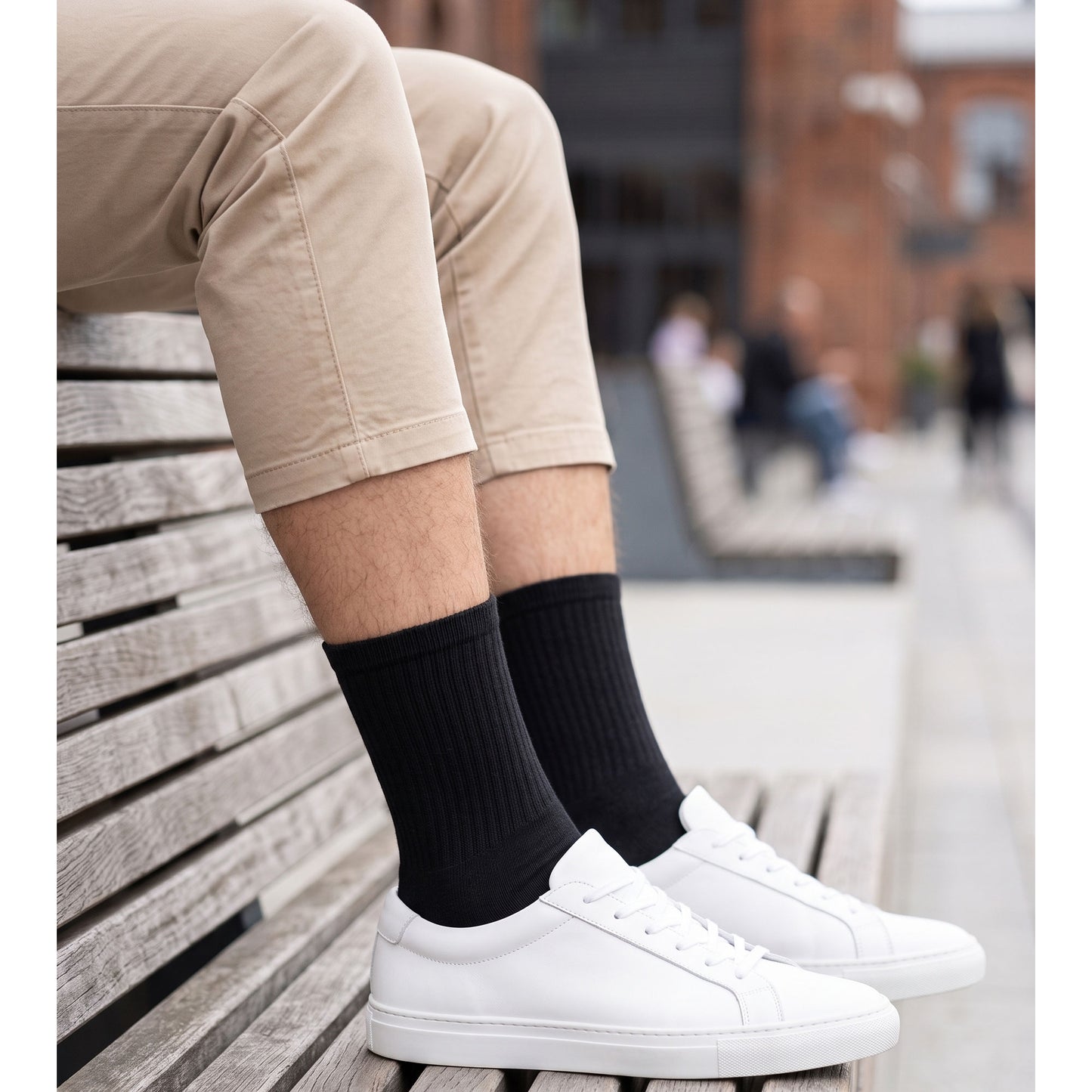 Man wearing black cotton crew socks with white sneakers