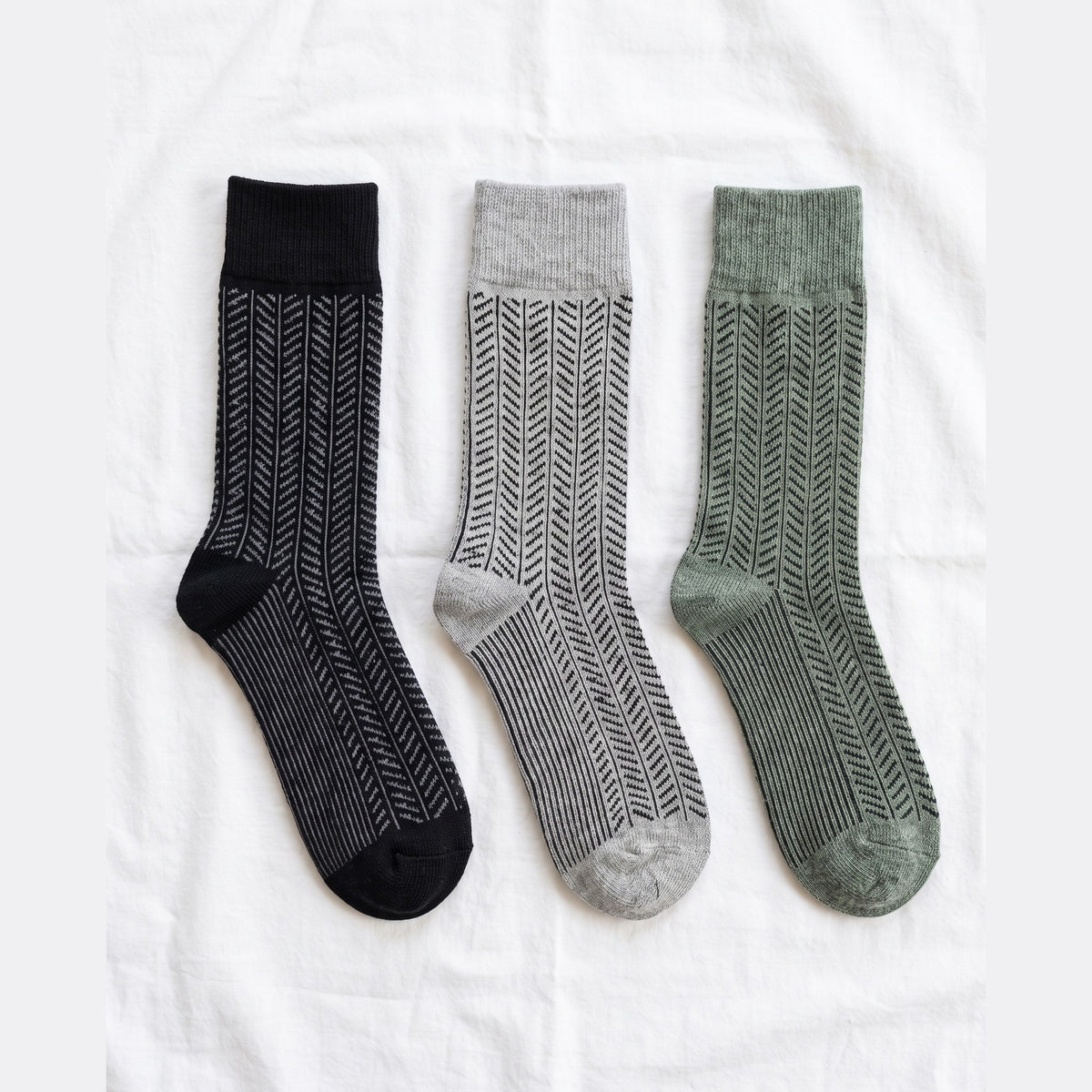 Louluu Herringbone lambswool crew socks in black, grey and khaki — flat lay