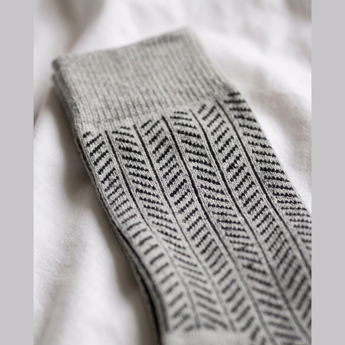 Close-up of grey herringbone lambswool sock showing the knitted herringbone pattern and plain cuff