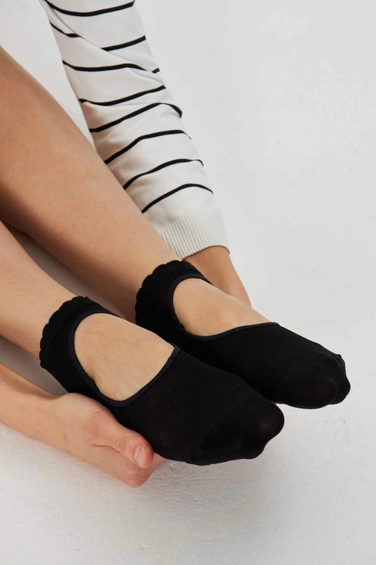 Model wearing black pilates grip socks with open instep window