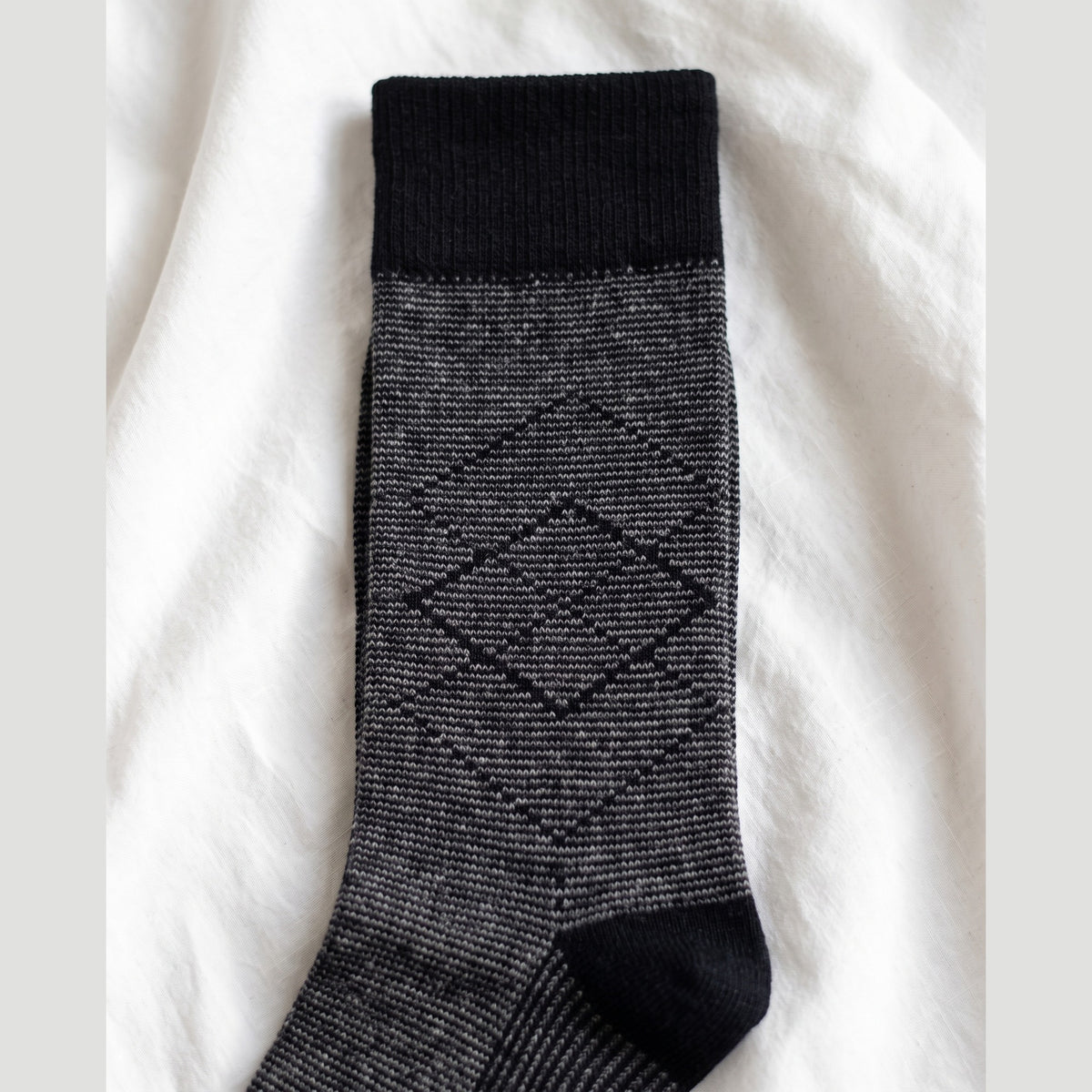Close-up of pinstripe lambswool sock showing the black diamond outline motif and black cuff