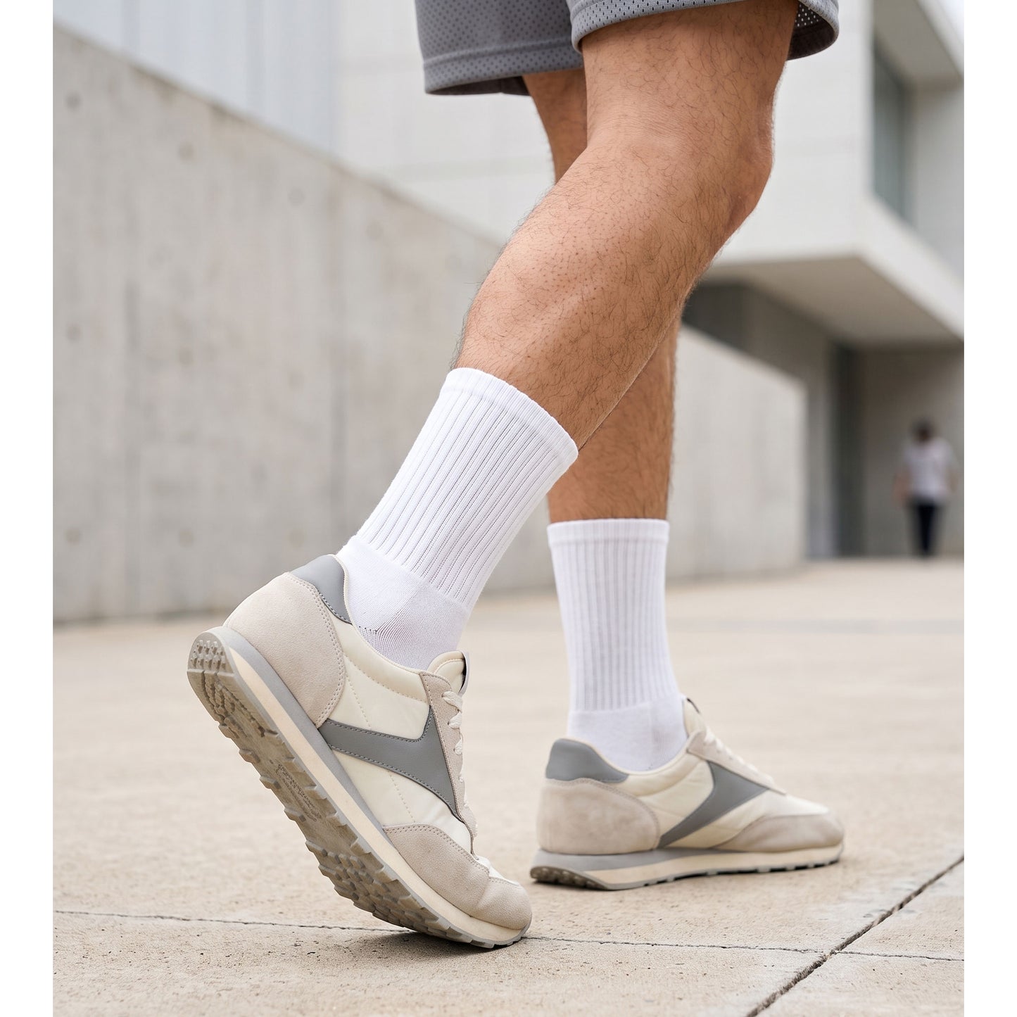Man wearing white cotton crew socks with retro trainers