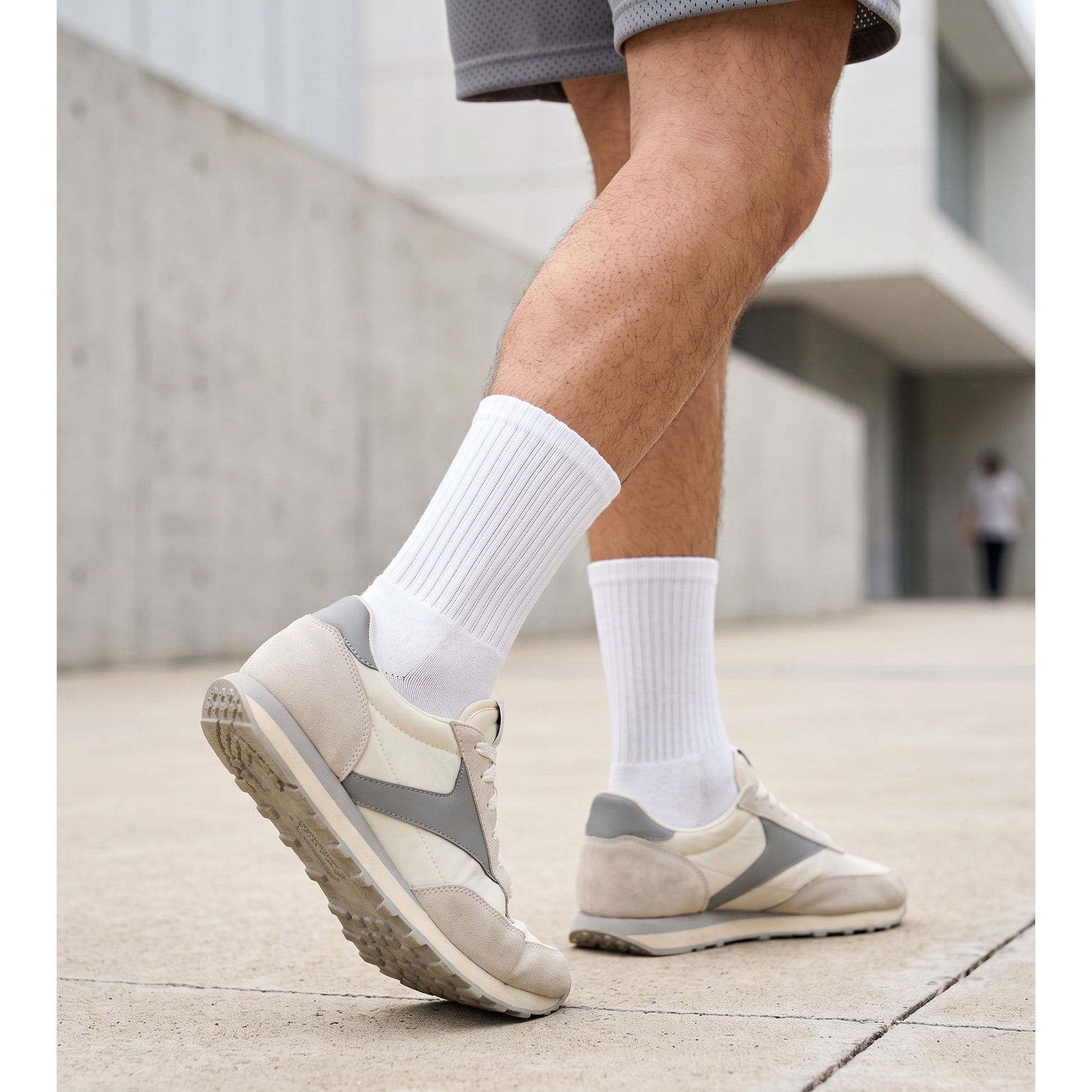 Man wearing white cotton crew socks with retro trainers