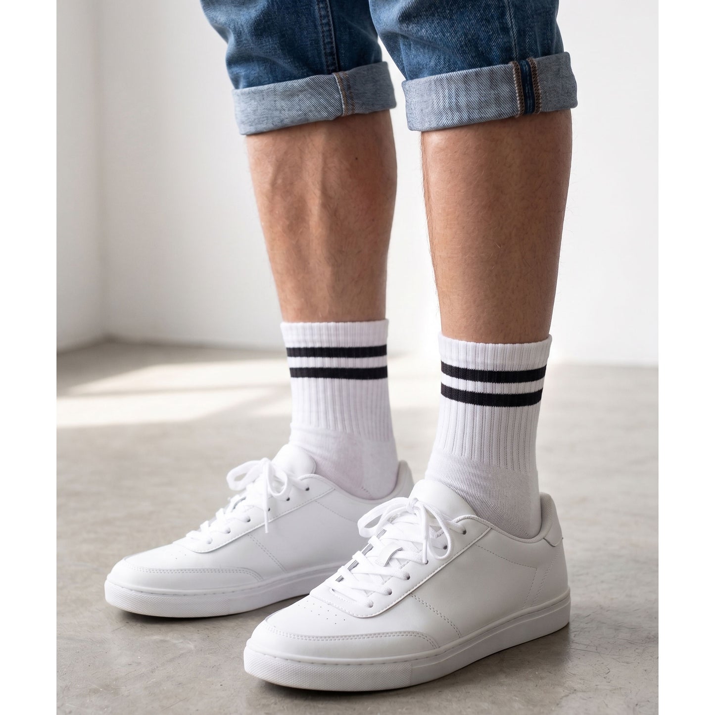 White half-crew socks with black stripes worn with white trainers and rolled jeans